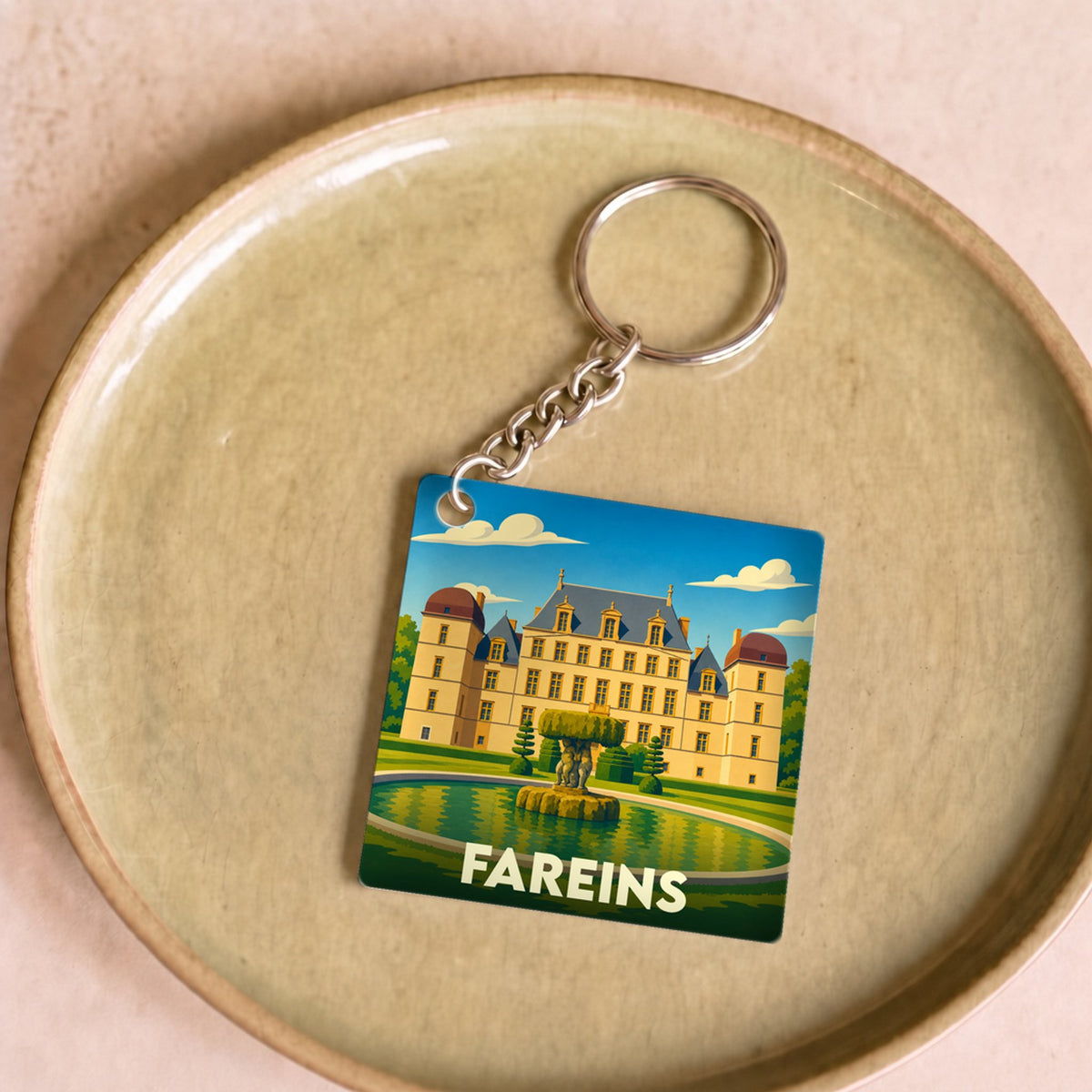 Porte-clés souvenir de la ville de Fareins avec une illustration stylisée de son château.
