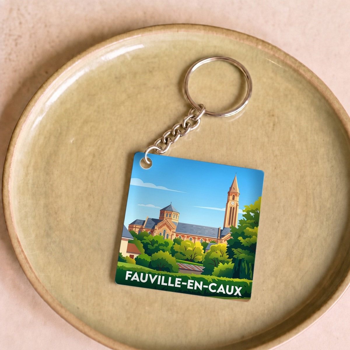 Porte-clés souvenir de la ville de Fauville-en-Caux avec une illustration stylisée de son église.
