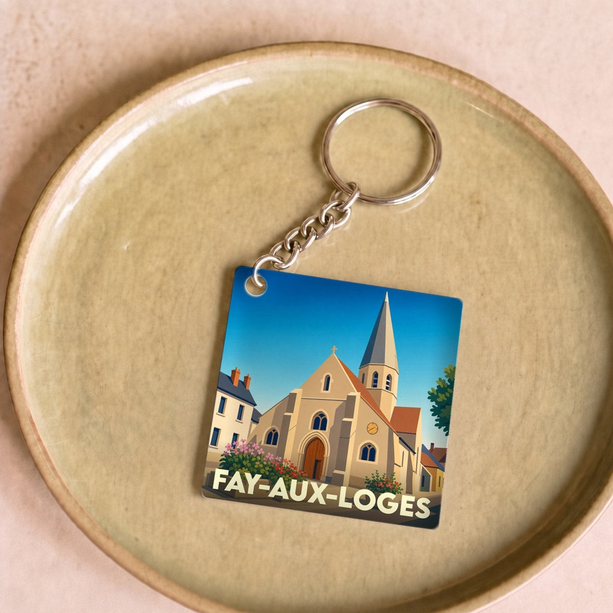 Porte-clés souvenir de la ville de Fay-aux-Loges avec une illustration stylisée de son église.