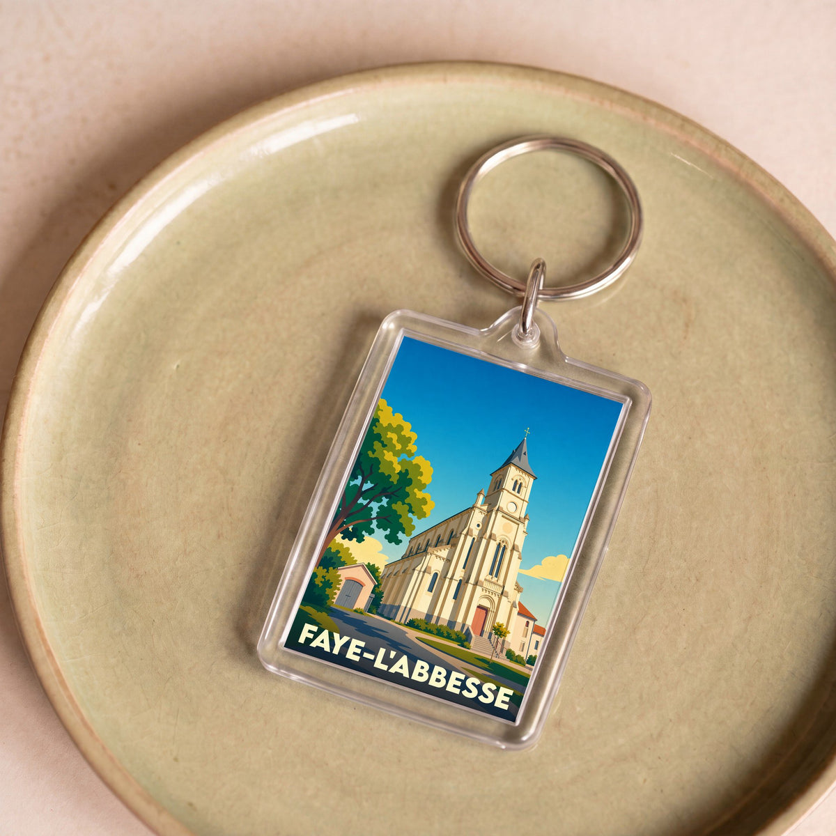 Porte-clés souvenir de la ville de Faye-l'Abbesse avec une illustration stylisée de son église.