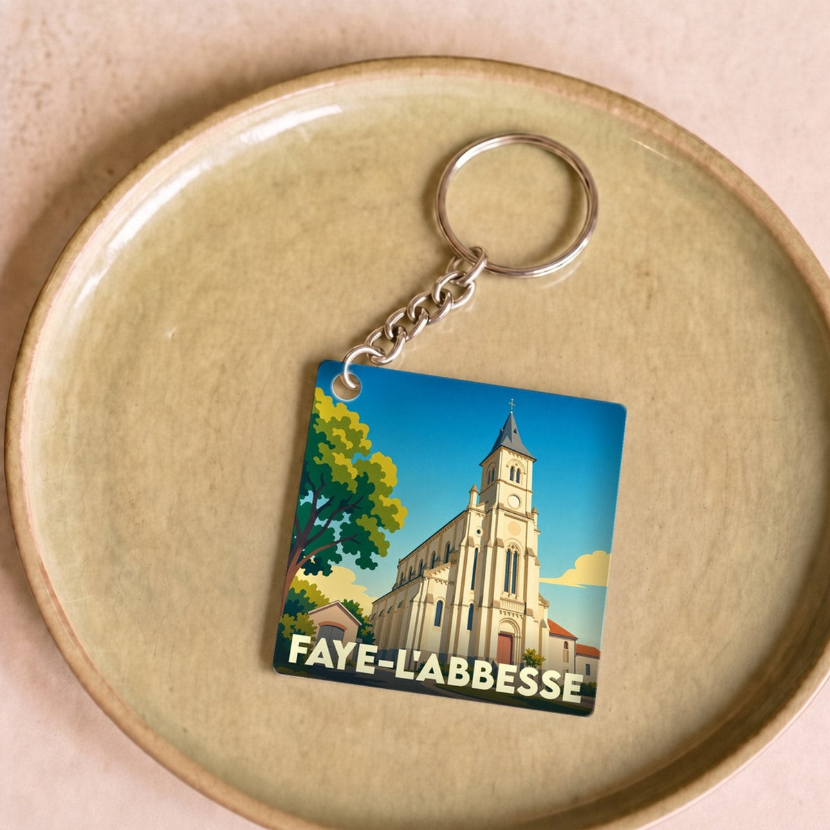 Porte-clés souvenir de la ville de Faye-l'Abbesse avec une illustration stylisée de son église.