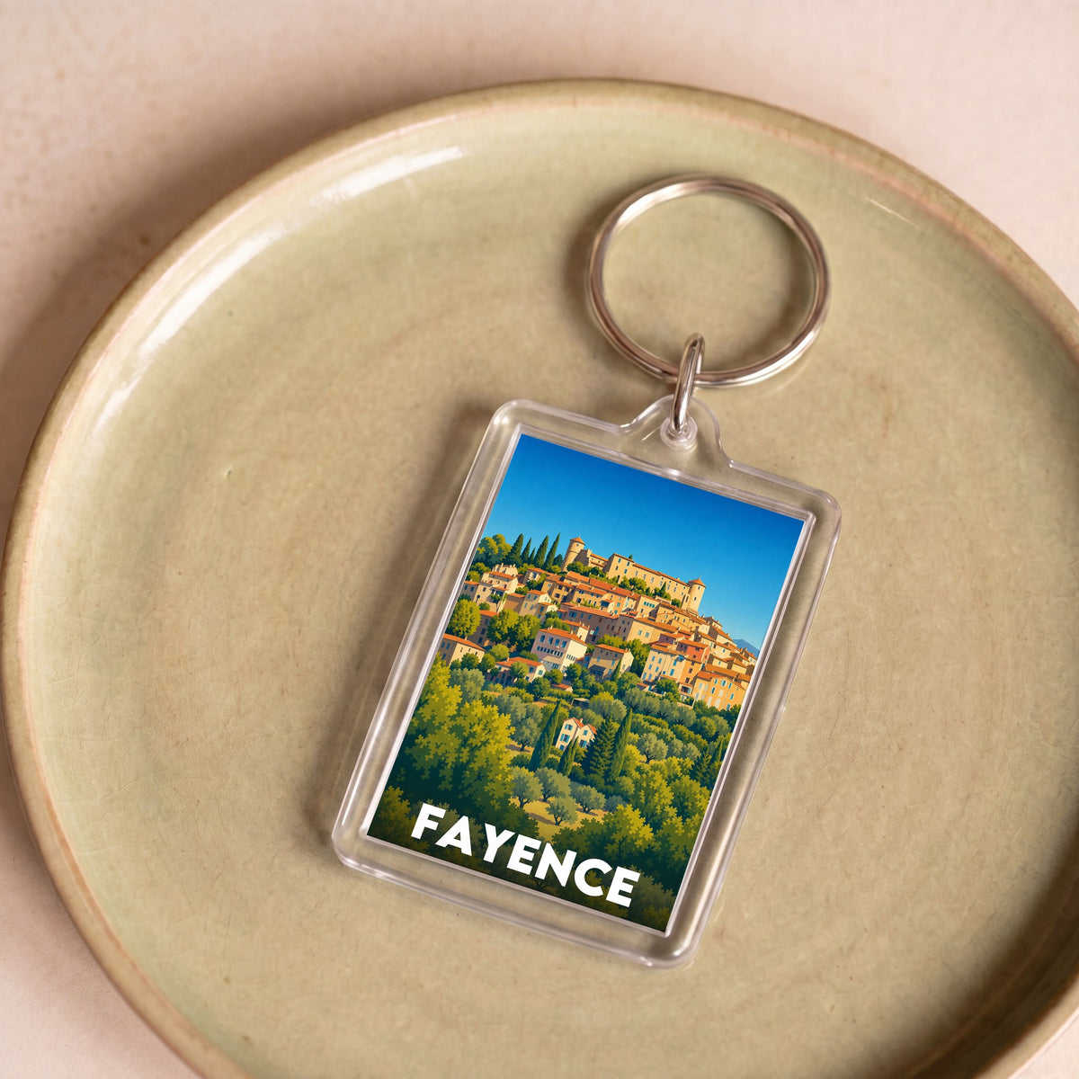 Porte-clés souvenir de la ville de Fayence avec une illustration stylisée du village.