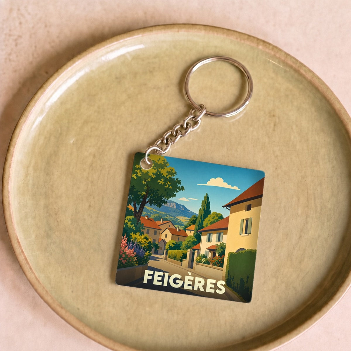 Porte-clés souvenir de la ville de Feigères avec une illustration stylisée.