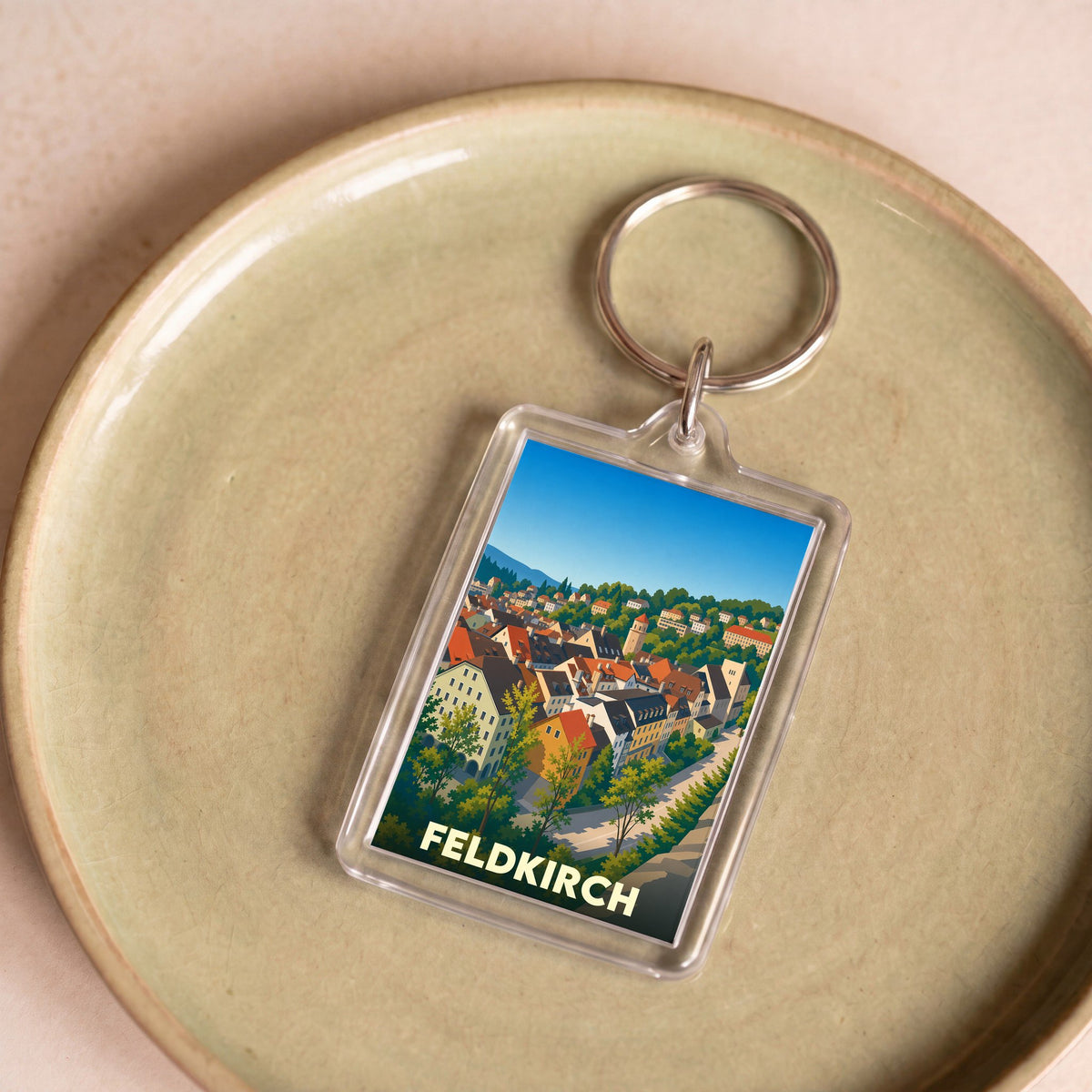 Porte-clés souvenir de la ville de Feldkirch avec une illustration colorée et stylisée de ses bâtiments.