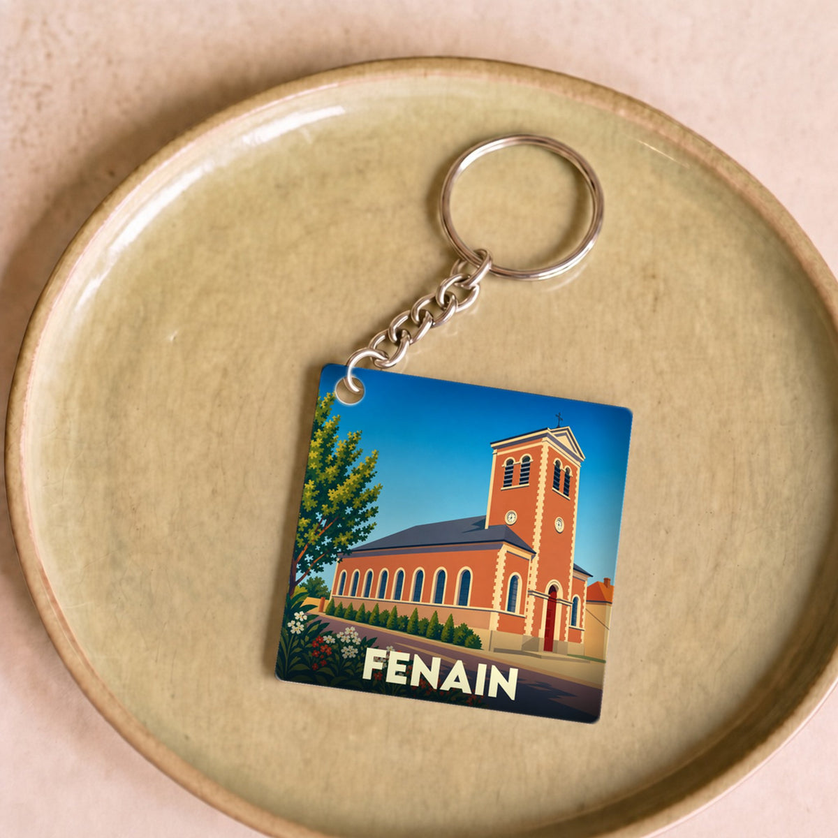 Porte-clés souvenir de la ville de Fenain avec une illustration stylisée de son église.