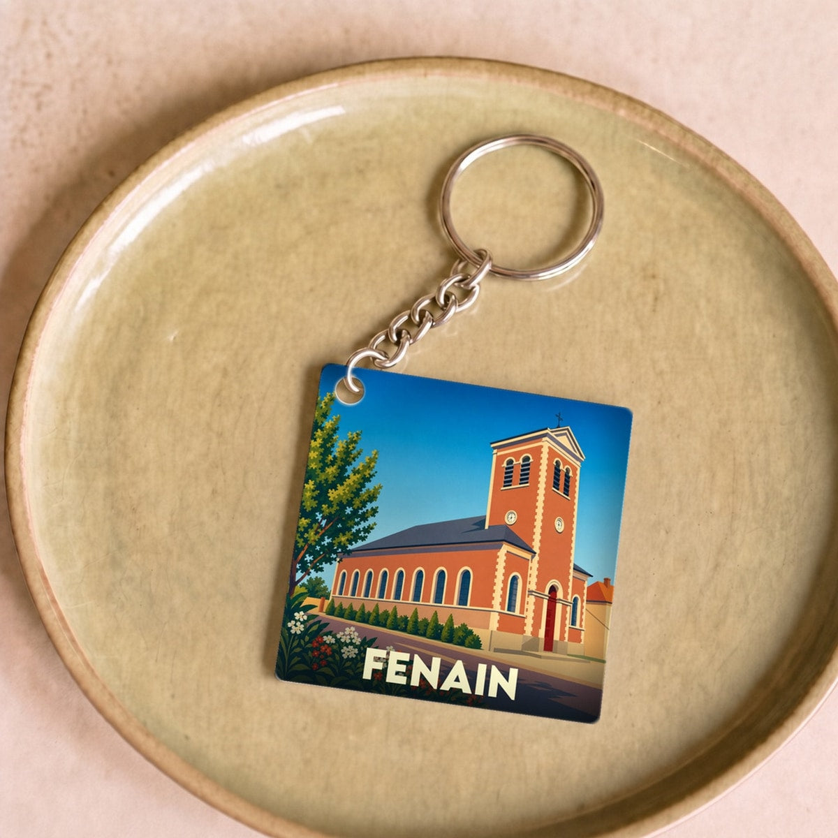 Porte-clés souvenir de la ville de Fenain avec une illustration stylisée de son église.