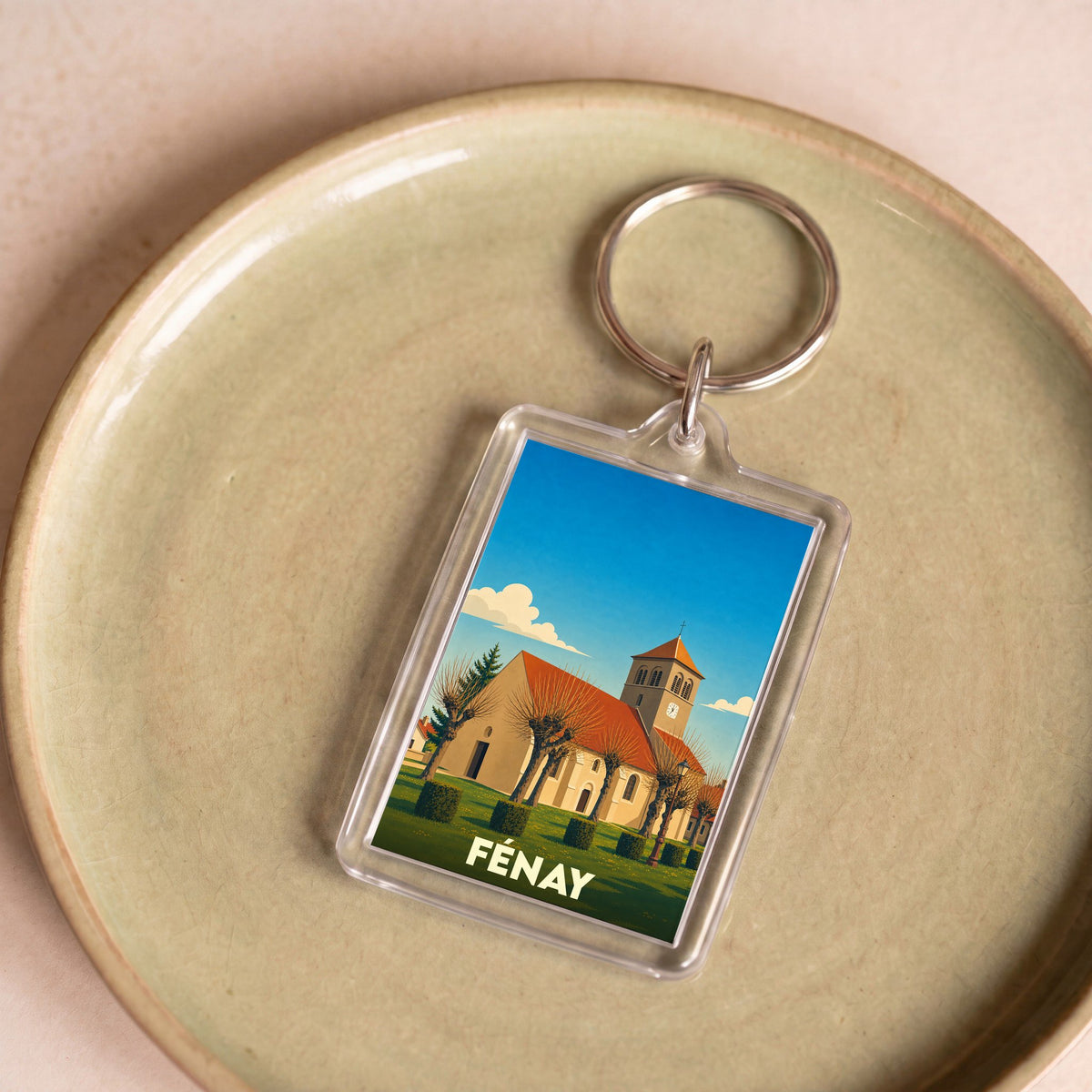 Porte-clés souvenir de la ville de Fénay avec une illustration stylisée de son église.