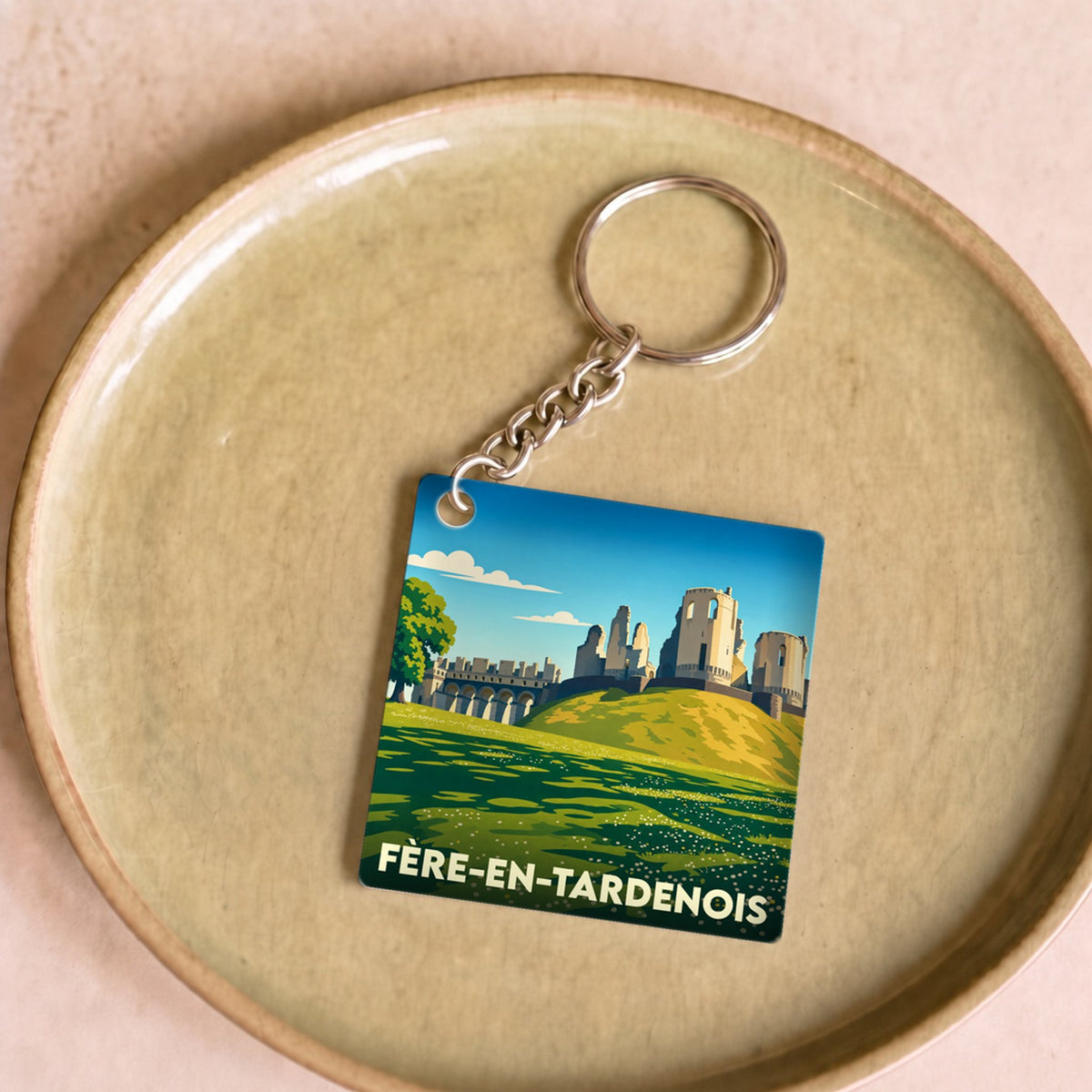 Porte-clés souvenir de la ville de Fère-en-Tardenois avec une illustration stylisée de son château.