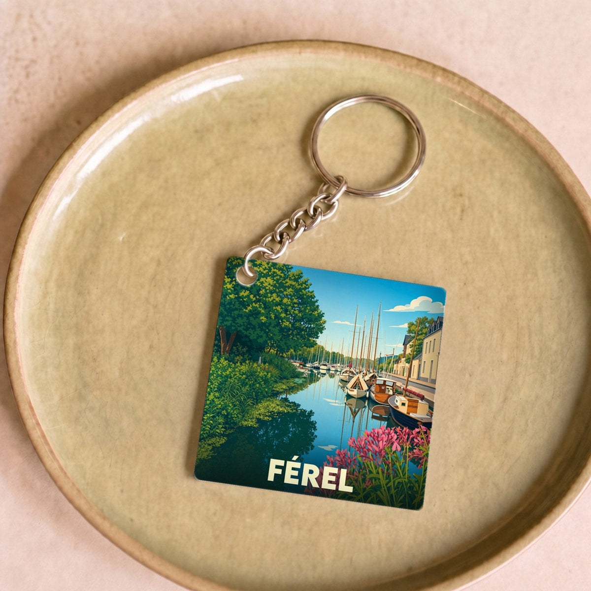 Porte-clés souvenir de la ville de Férel avec une illustration stylisée d'un port fleuri.