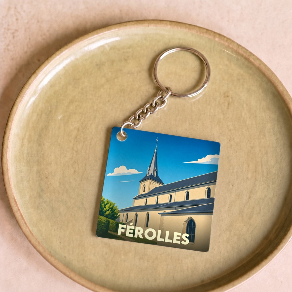 Porte-clés souvenir de la ville de Férolles avec une illustration stylisée de son église.