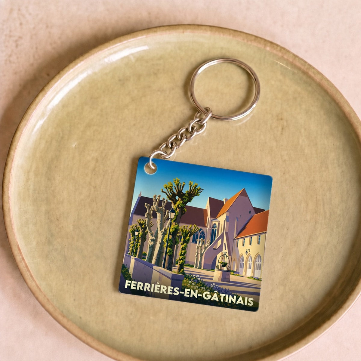 Porte-clés souvenir de la ville de Ferrières-en-Gâtinais avec une illustration stylisée.
