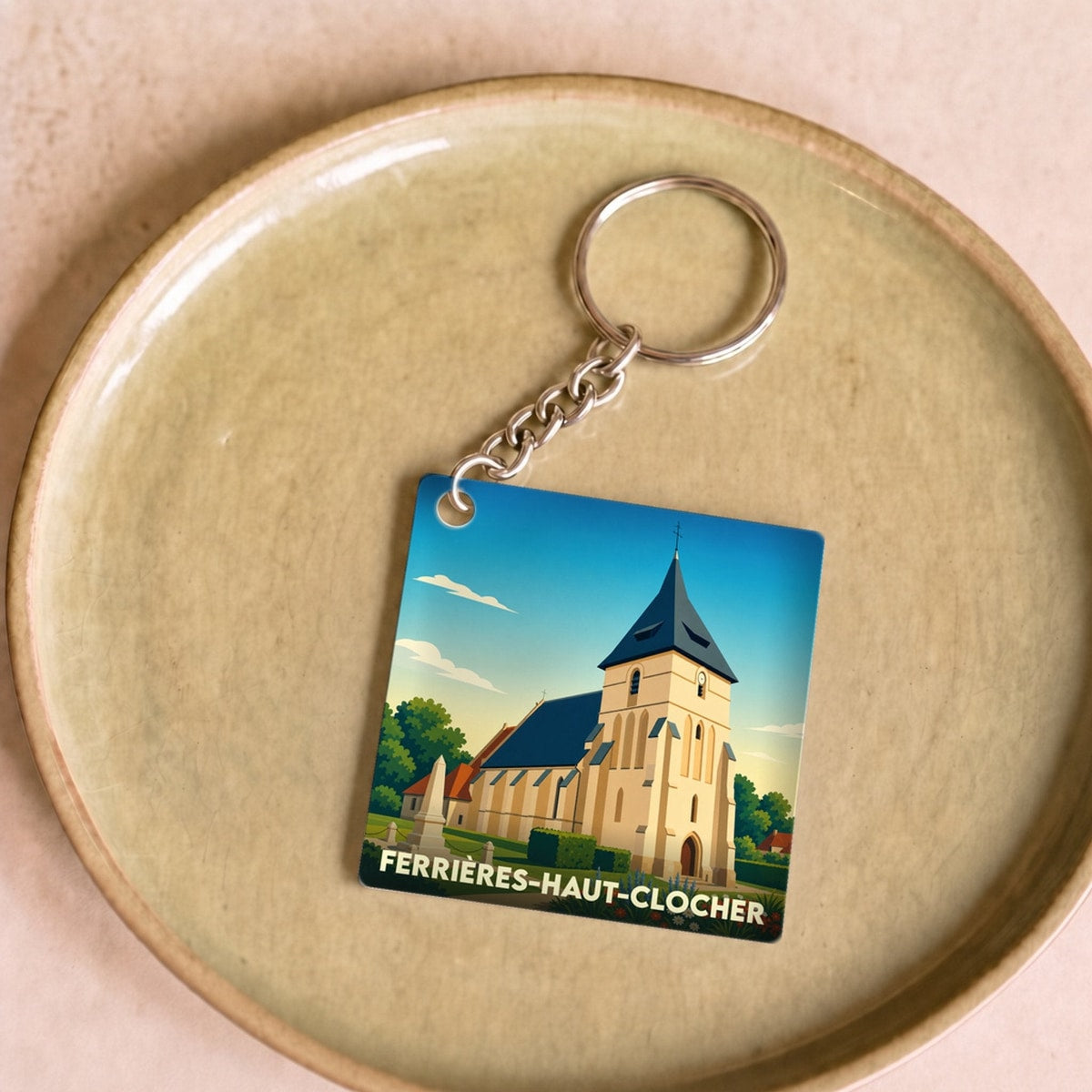 Porte-clés souvenir de la ville de Ferrières-Haut-Clocher avec une illustration stylisée de son église.