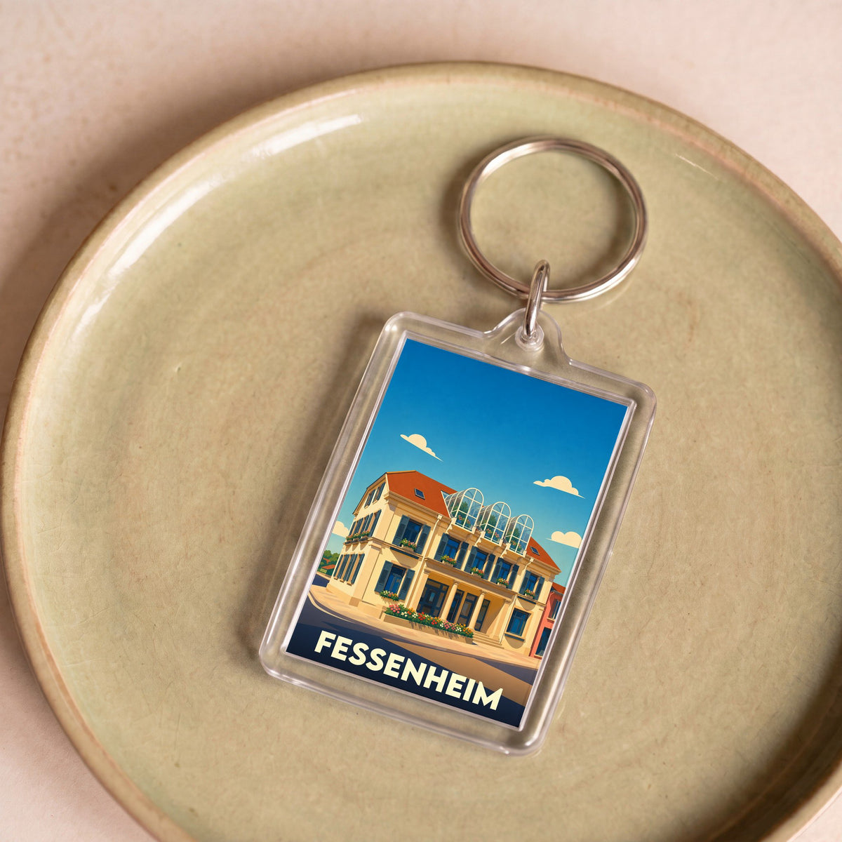 Porte-clés souvenir de la ville de Fessenheim avec une illustration stylisée d'un bâtiment remarquable.