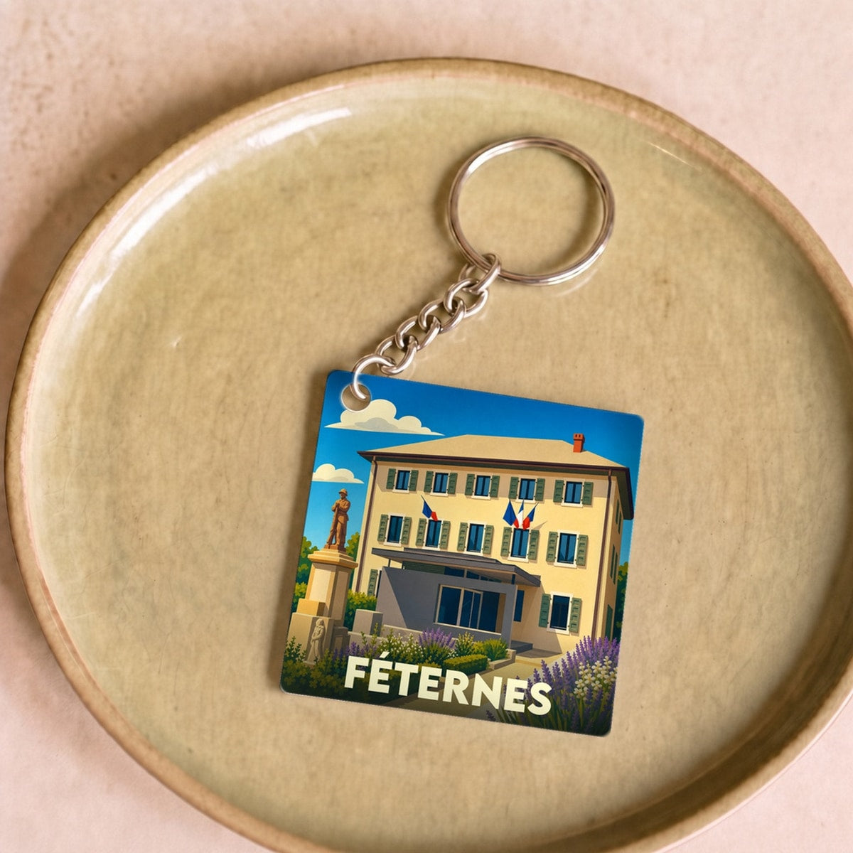 Porte-clés souvenir de la ville de Féternes avec une illustration stylisée de la mairie.
