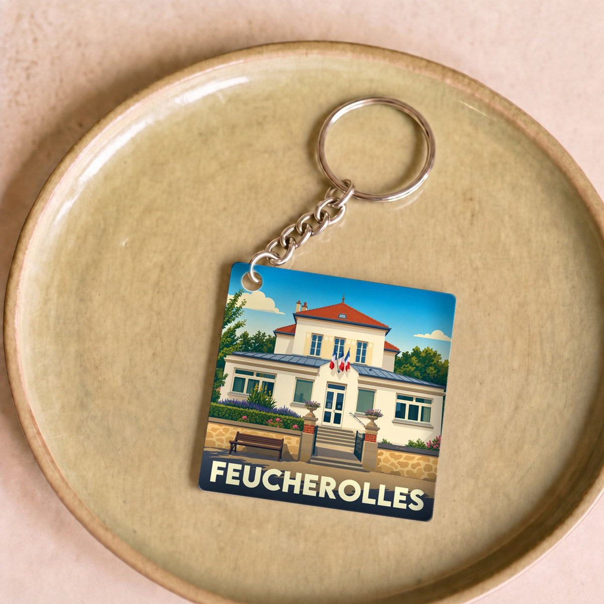 Porte-clés souvenir de la ville de Feucherolles avec une illustration stylisée de sa mairie.