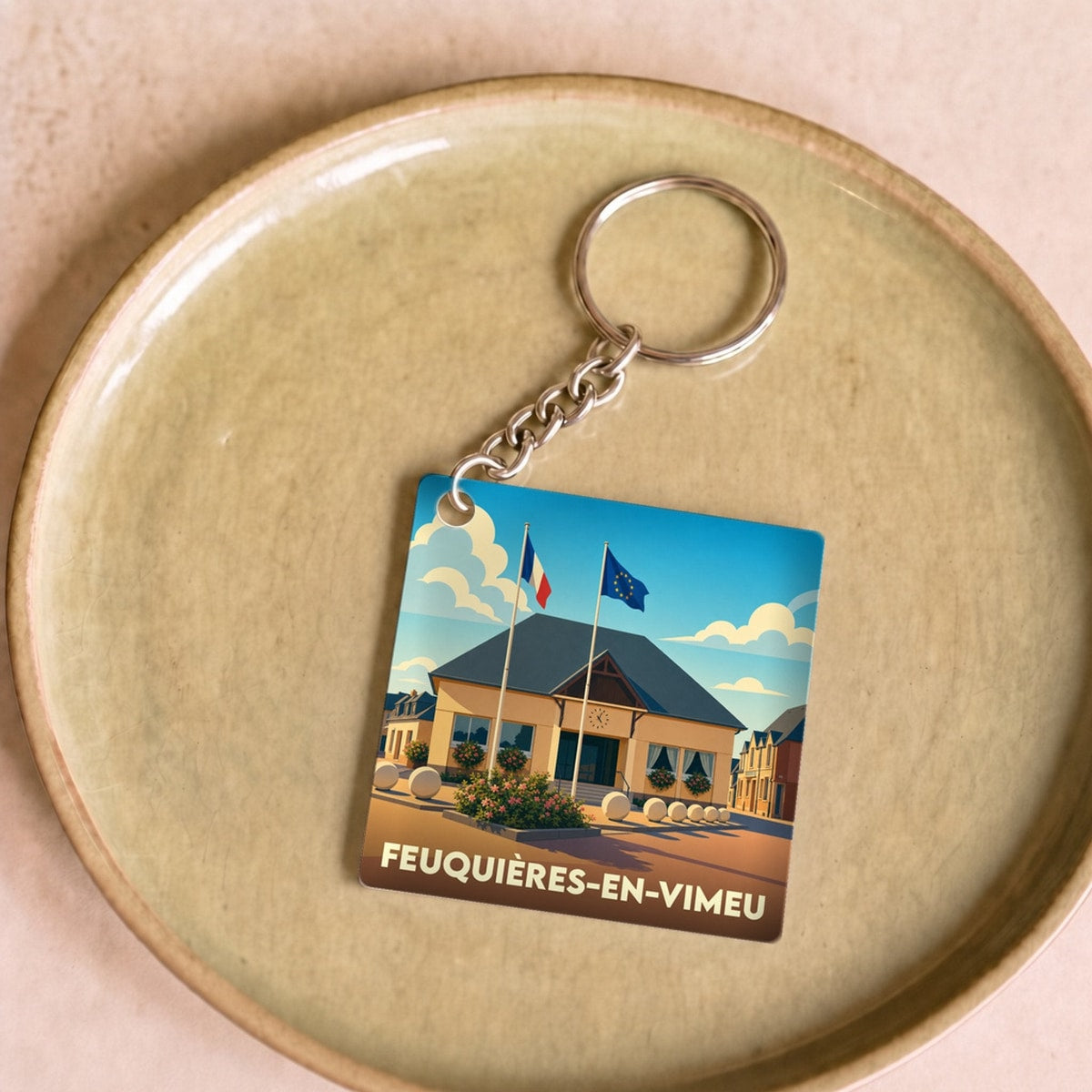 Porte-clés souvenir de la ville de Feuquières-en-Vimeu avec une illustration stylisée de sa mairie.
