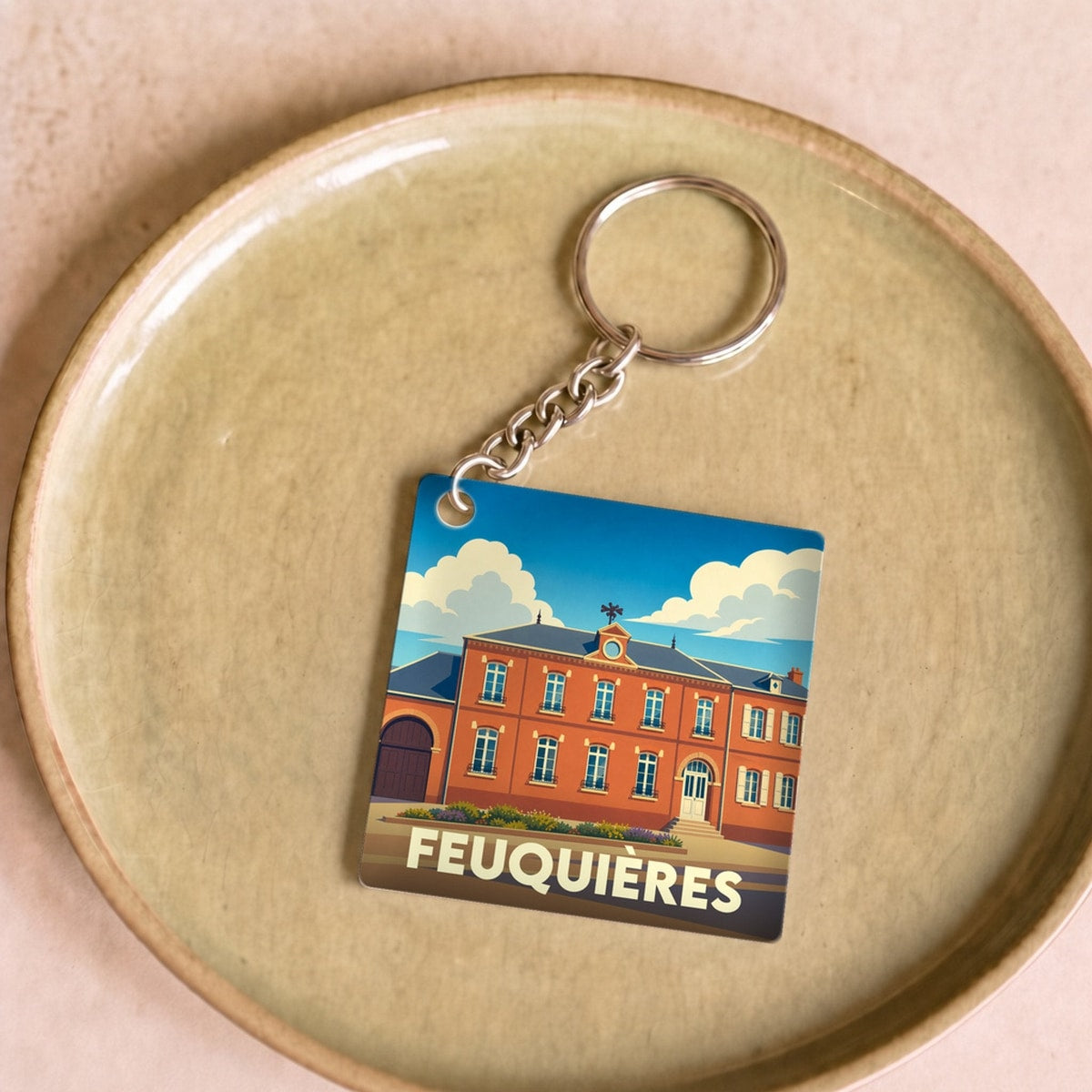 Porte-clés souvenir de la ville de Feuquières avec une illustration stylisée de sa mairie.