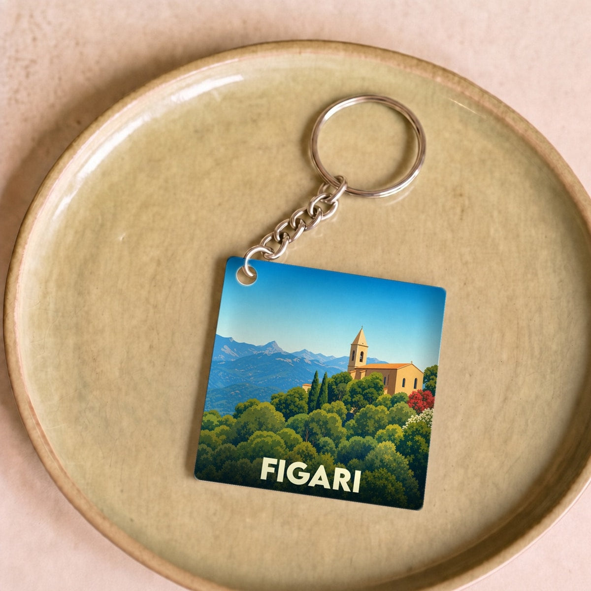 Porte-clés souvenir de la ville de Figari avec une illustration stylisée de son paysage et de son église.