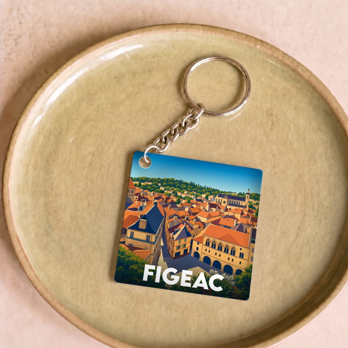 Porte-clés souvenir de la ville de Figeac avec une illustration stylisée de ses toits.