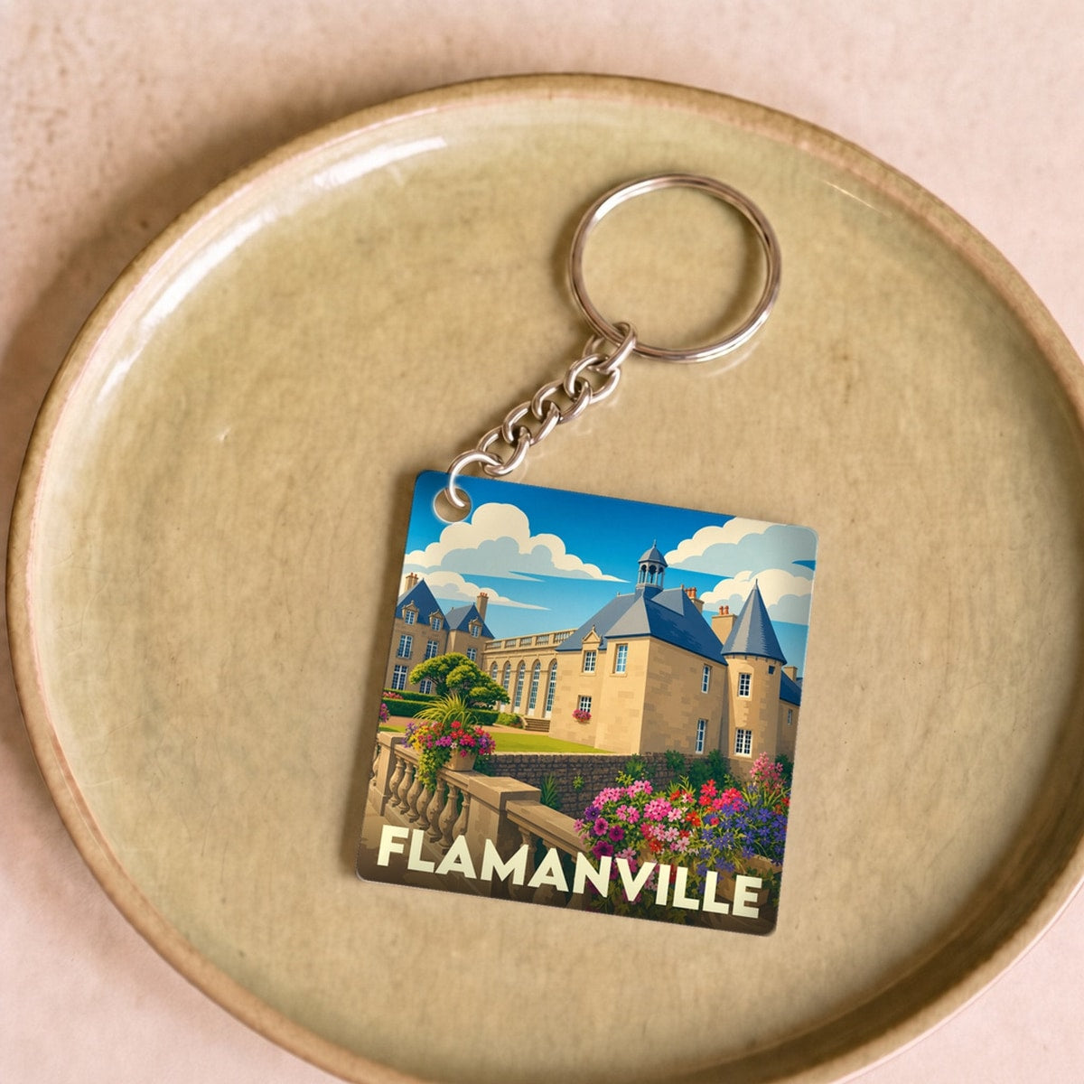 Porte-clés souvenir de la ville de Flamanville avec une illustration stylisée de son château.