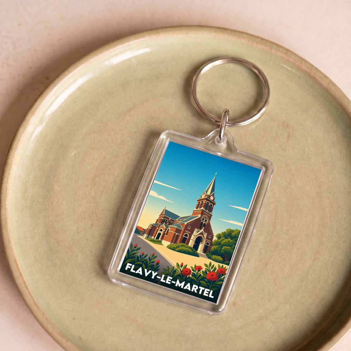Porte-clés souvenir de la ville de Flavy-le-Martel avec une illustration stylisée.