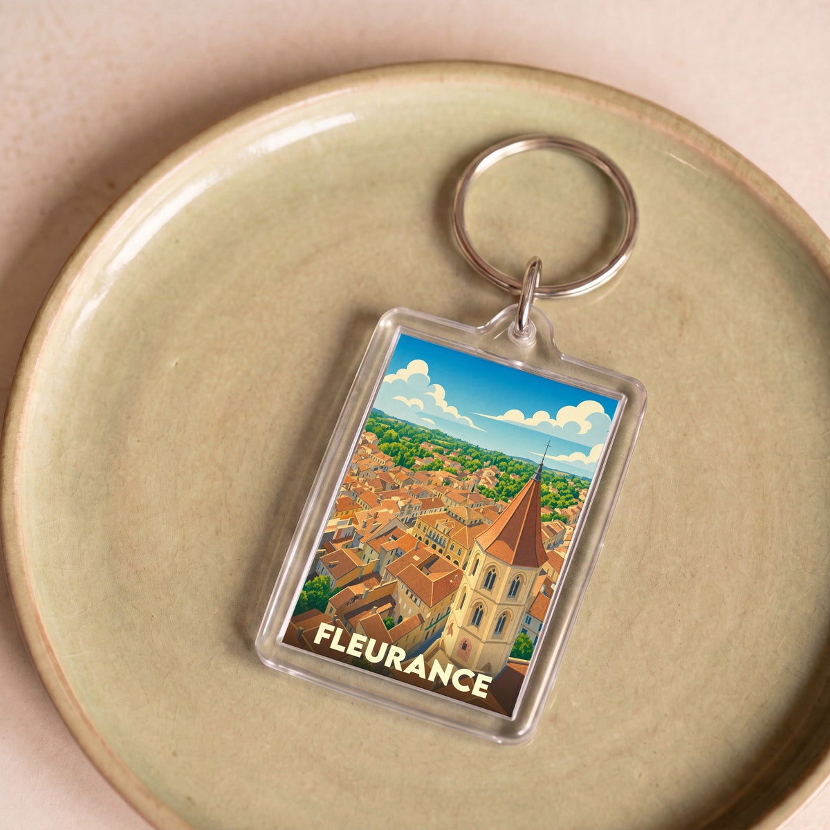 Porte-clés souvenir de la ville de Fleurance avec une illustration stylisée vue du ciel.