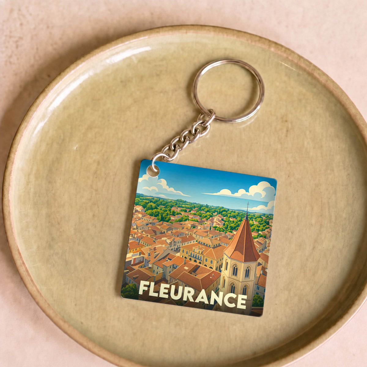 Porte-clés souvenir de la ville de Fleurance avec une illustration stylisée vue du ciel.