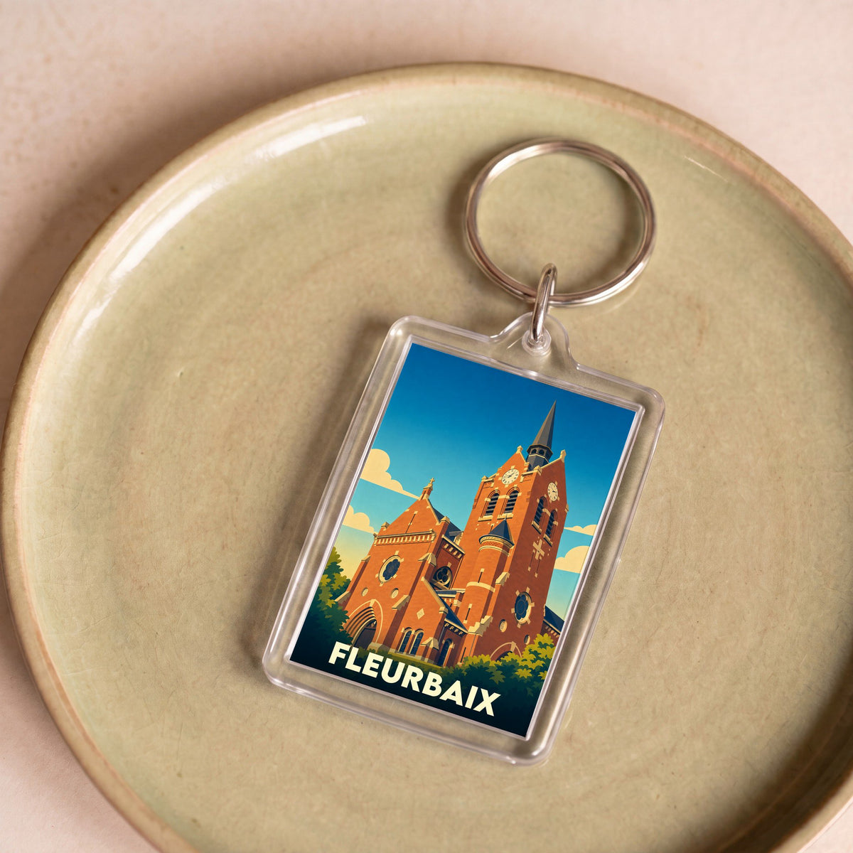 Porte-clés souvenir de la ville de Fleurbaix avec une illustration stylisée de son église.