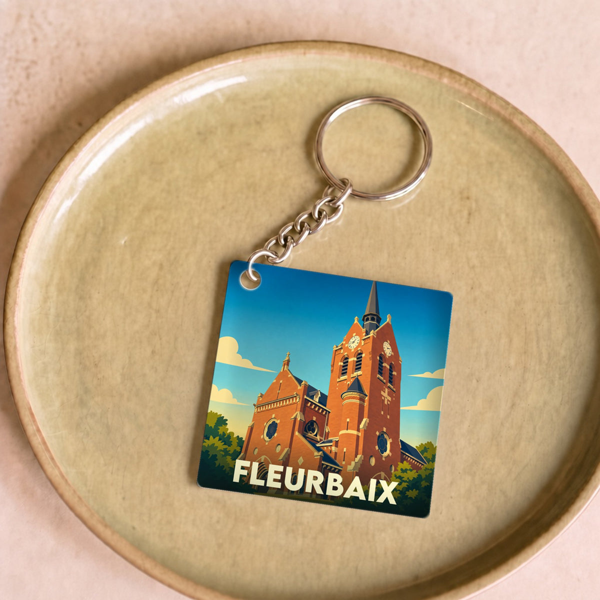 Porte-clés souvenir de la ville de Fleurbaix avec une illustration stylisée de son église.