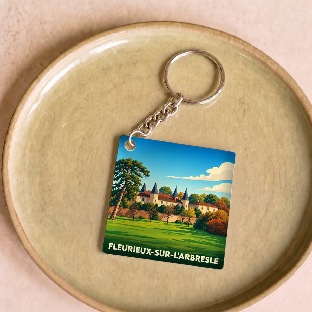 Porte-clés souvenir de la ville de Fleurieux-sur-l'Arbresle avec une illustration stylisée d'un château.