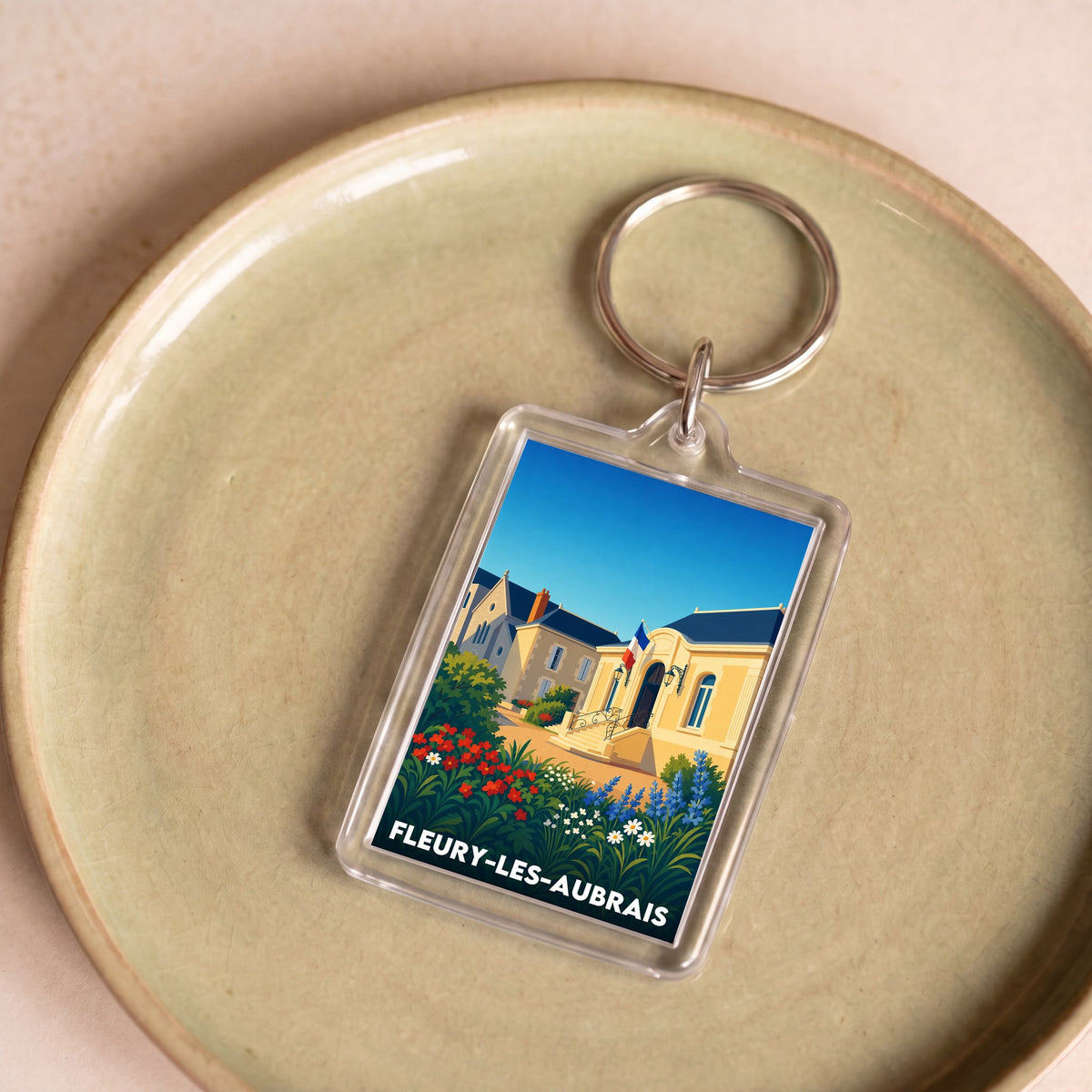 Porte-clés souvenir de la ville de Fleury-les-Aubrais avec une illustration stylisée.