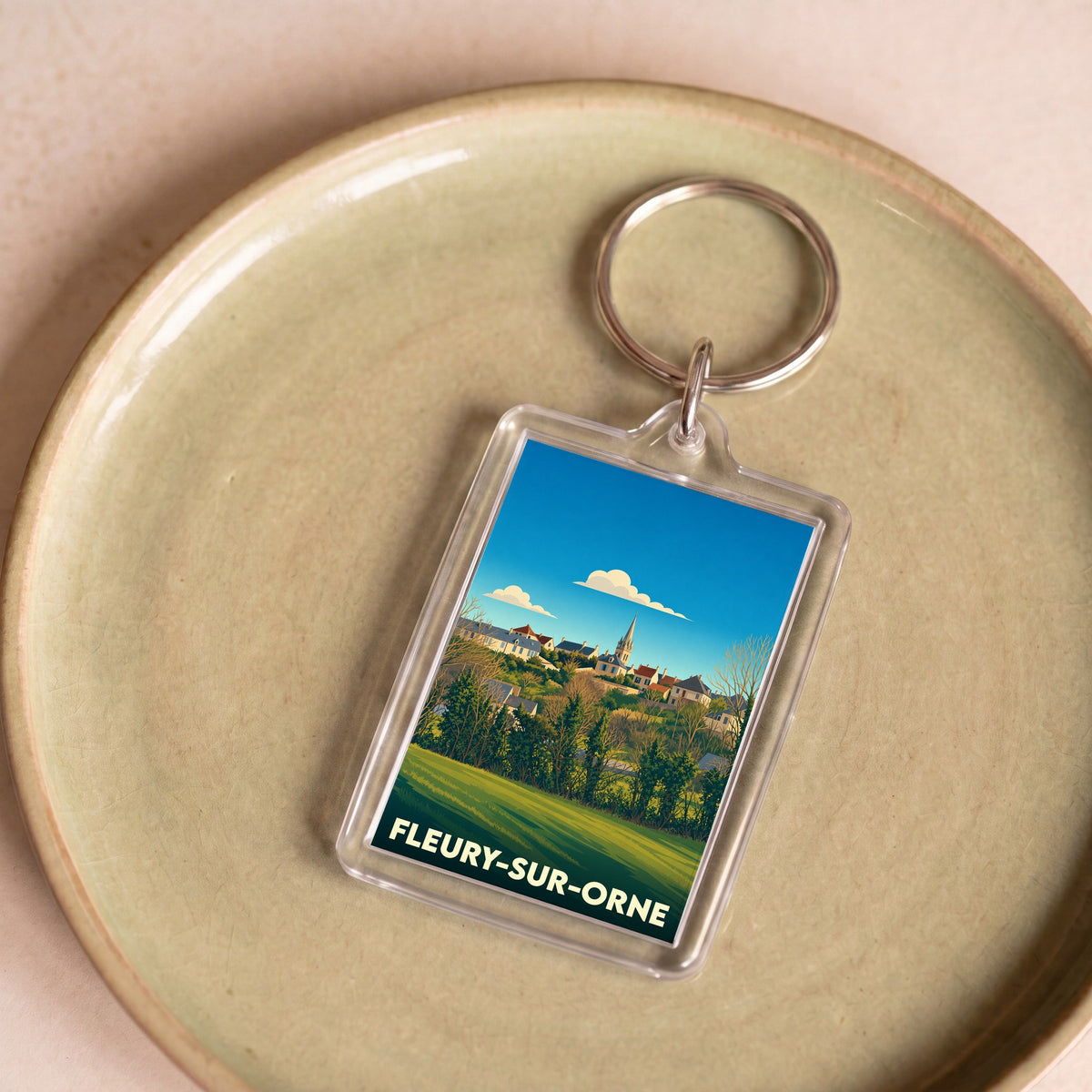 Porte-clés souvenir de la ville de Fleury-sur-Orne avec une illustration stylisée.