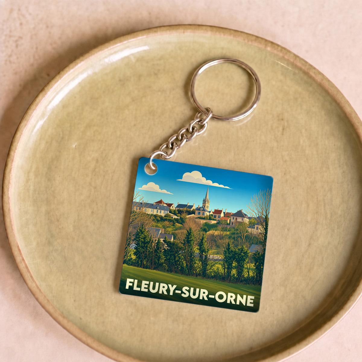 Porte-clés souvenir de la ville de Fleury-sur-Orne avec une illustration stylisée.
