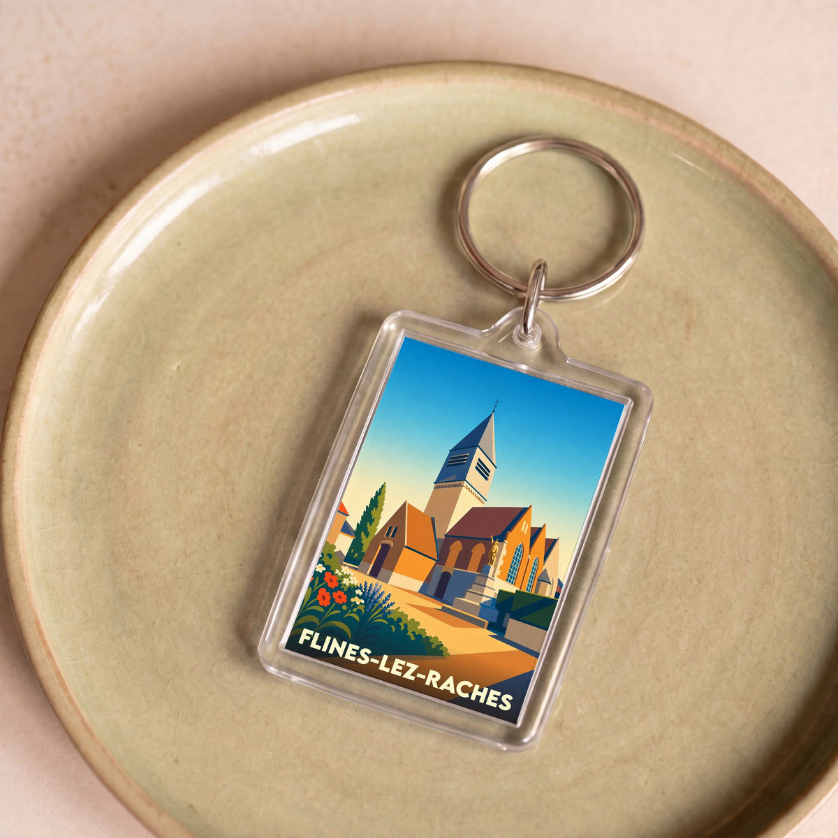 Porte-clés souvenir de la ville de Flines-lez-Raches avec une illustration stylisée de son église.