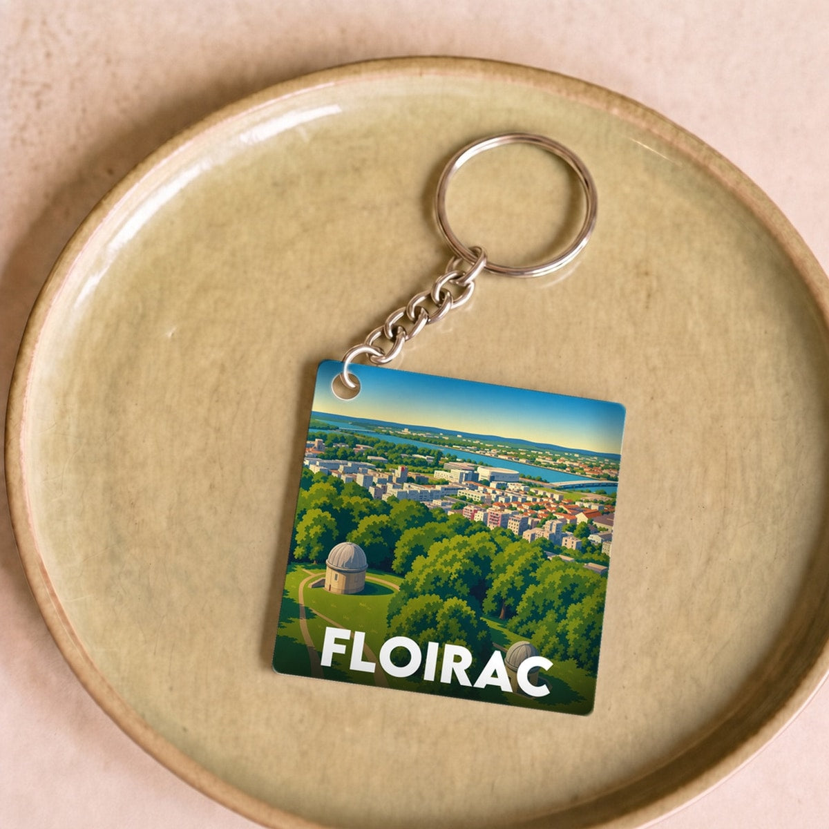 Porte-clés souvenir de la ville de Floirac avec une illustration paysagère stylisée.