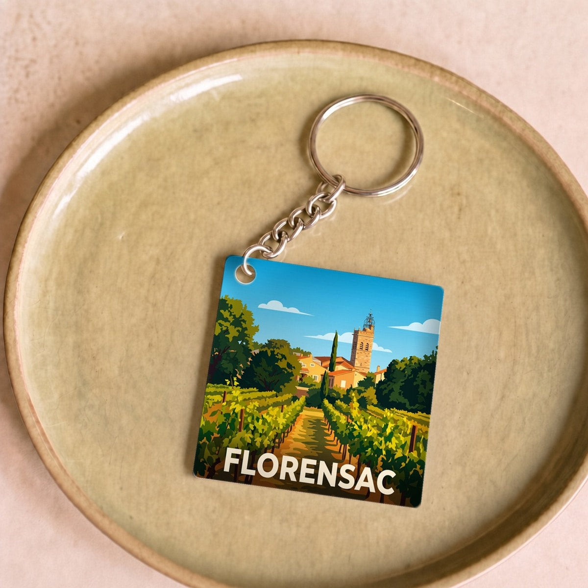 Porte-clés souvenir de la ville de Florensac avec une illustration stylisée.