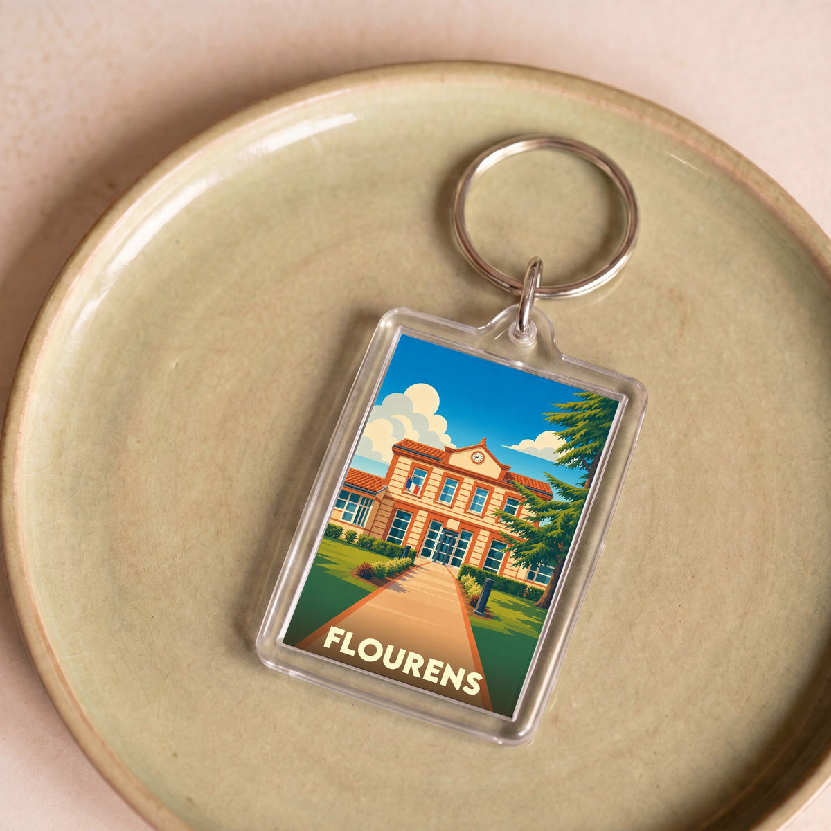 Porte-clés souvenir de la ville de Flourens avec une illustration stylisée de sa mairie.