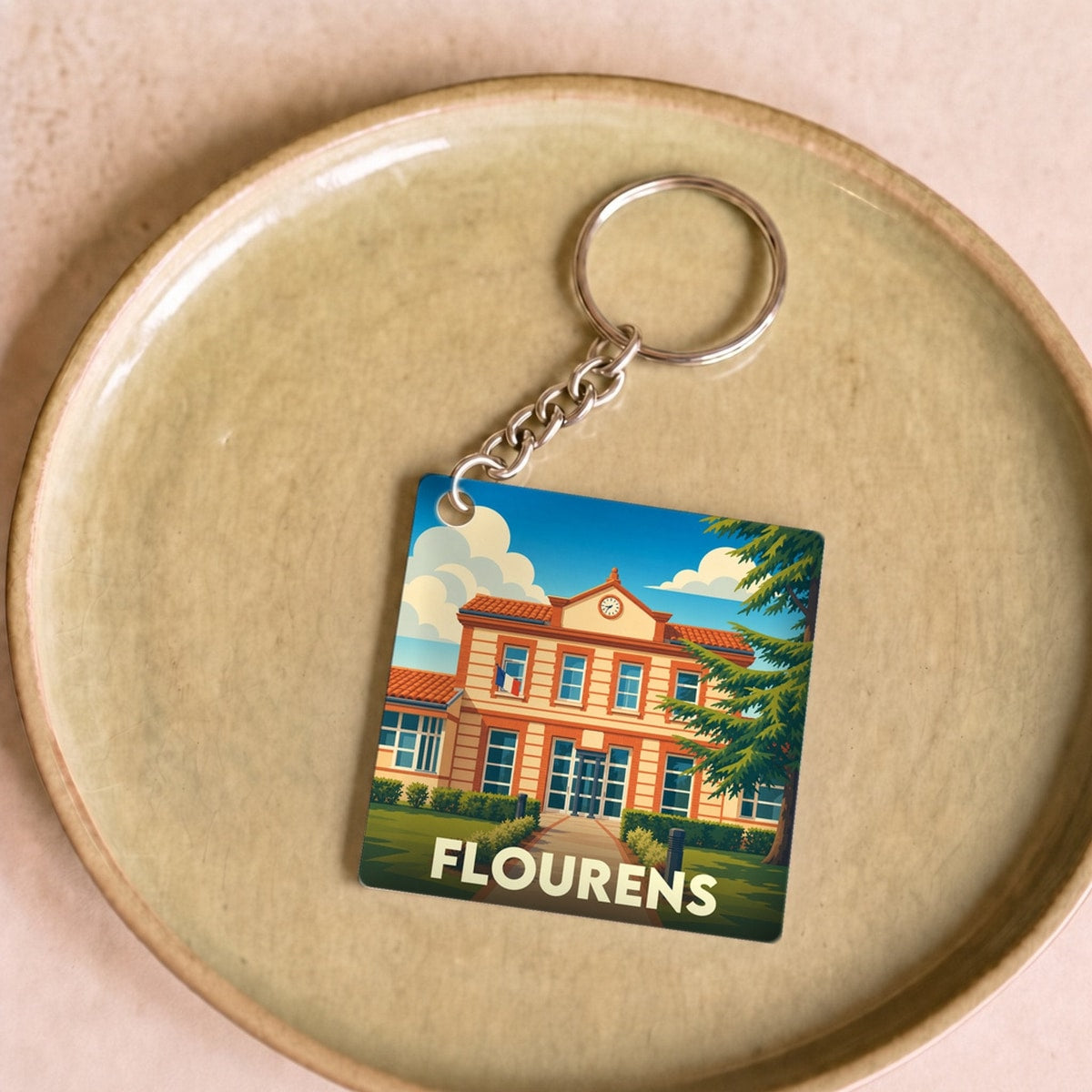 Porte-clés souvenir de la ville de Flourens avec une illustration stylisée de sa mairie.
