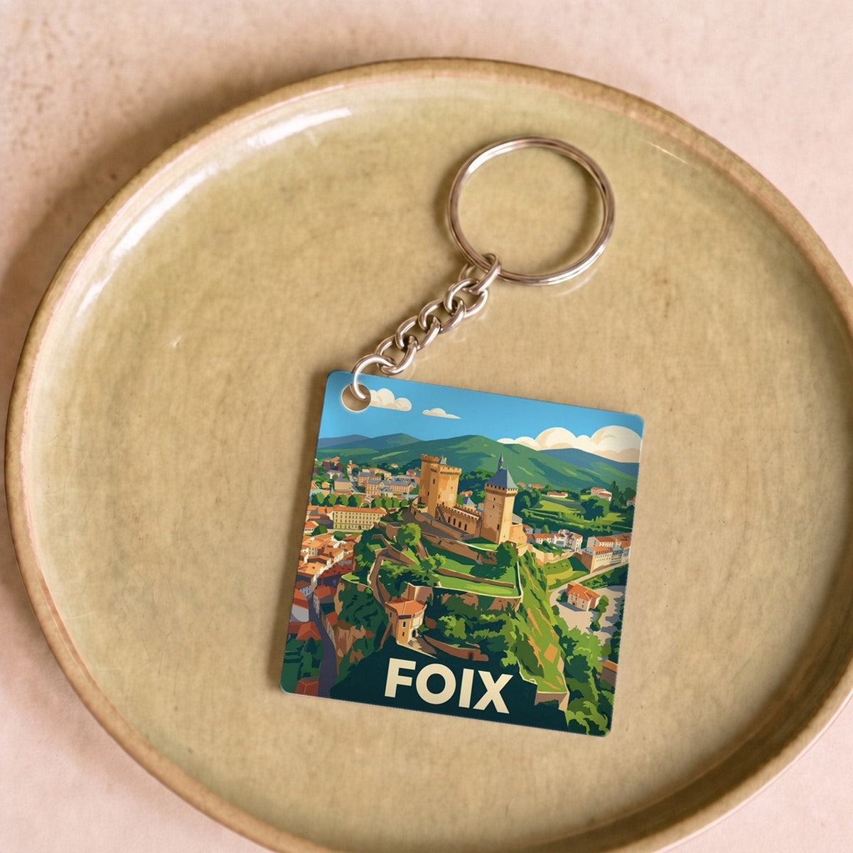 Porte-clés souvenir de la ville de Foix avec une illustration stylisée.
