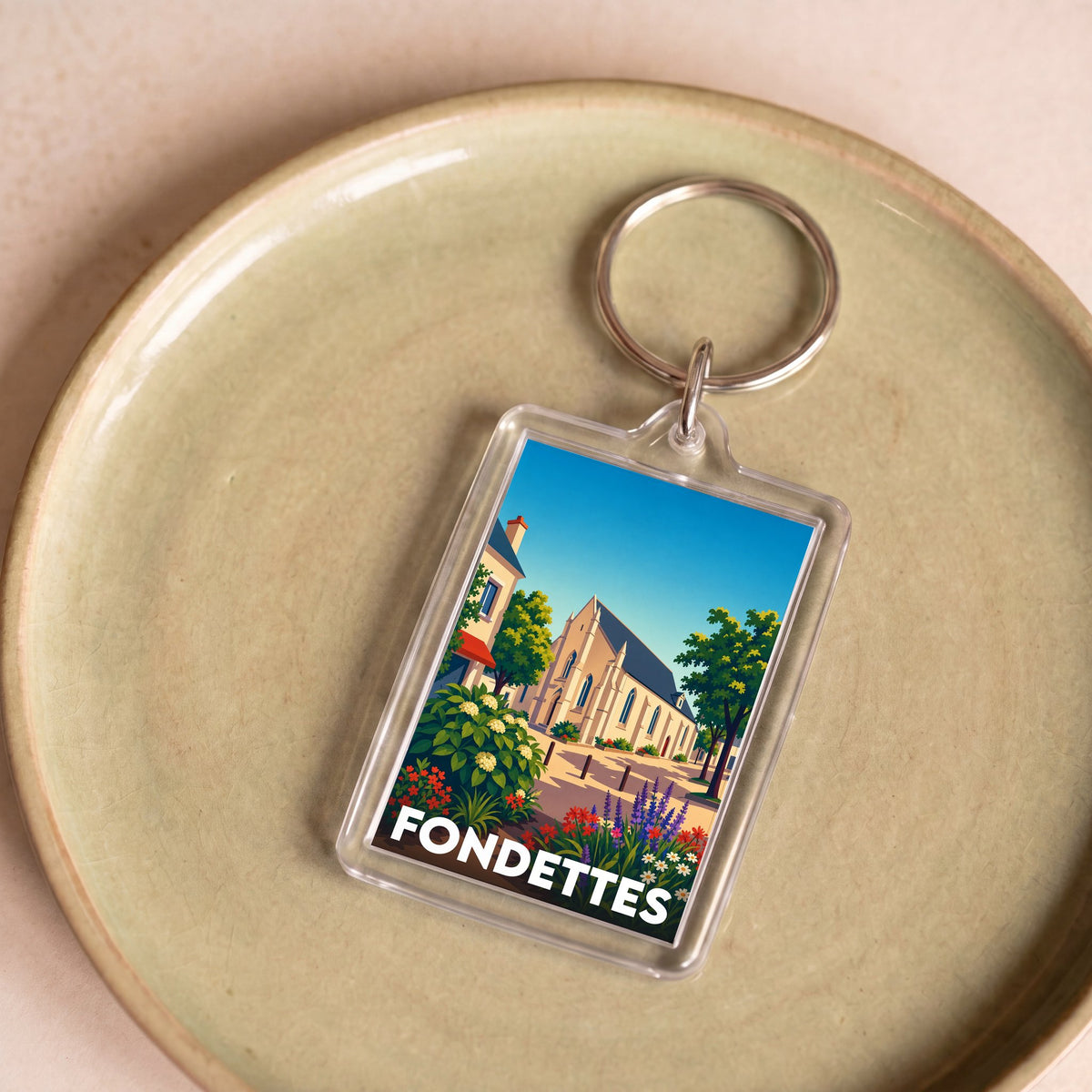 Porte-clés souvenir de la ville de Fondettes avec une illustration stylisée d'une église sous un ciel bleu.