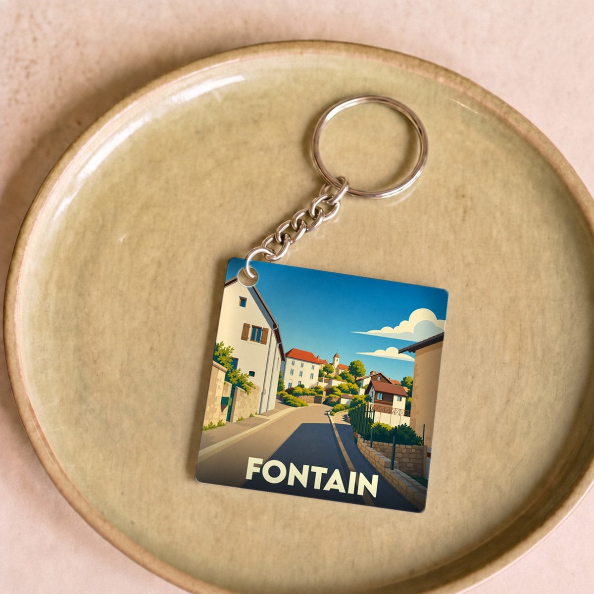 Porte-clés souvenir de la ville de Fontain avec une illustration stylisée.