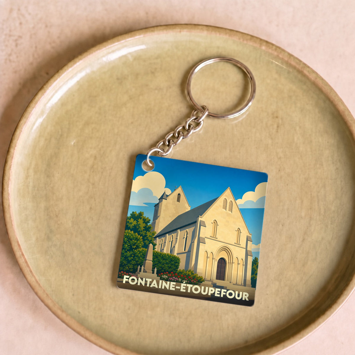 Porte-clés souvenir de la ville de Fontaine-Étoupefour avec une illustration stylisée de son église.