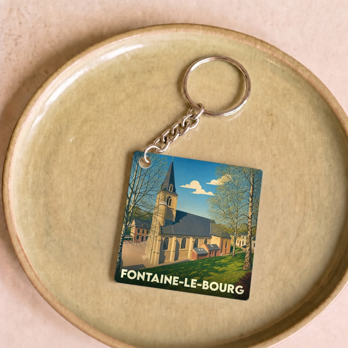 Porte-clés souvenir de la ville de Fontaine-le-Bourg avec une illustration stylisée de son église.