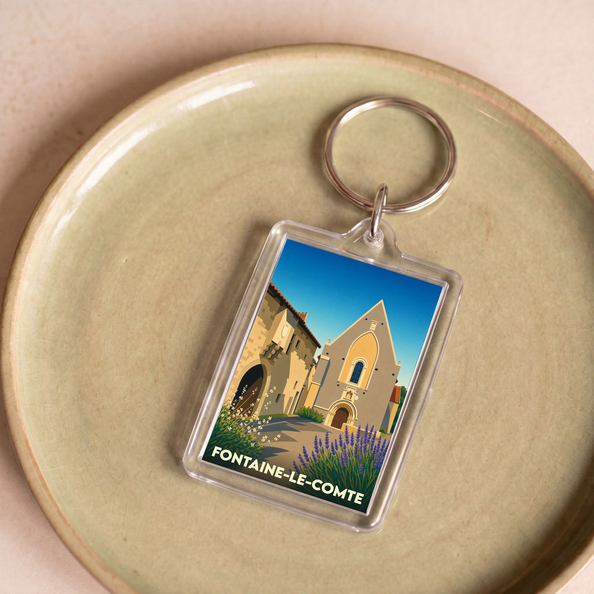 Porte-clés souvenir de la ville de Fontaine-le-Comte avec une illustration stylisée de son église et de lavandes.