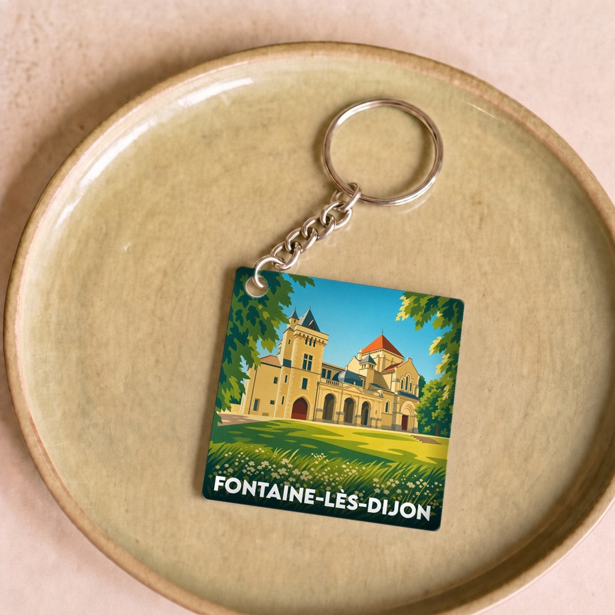 Porte-clés souvenir de la ville de Fontaine-lès-Dijon avec une illustration stylisée du patrimoine local.