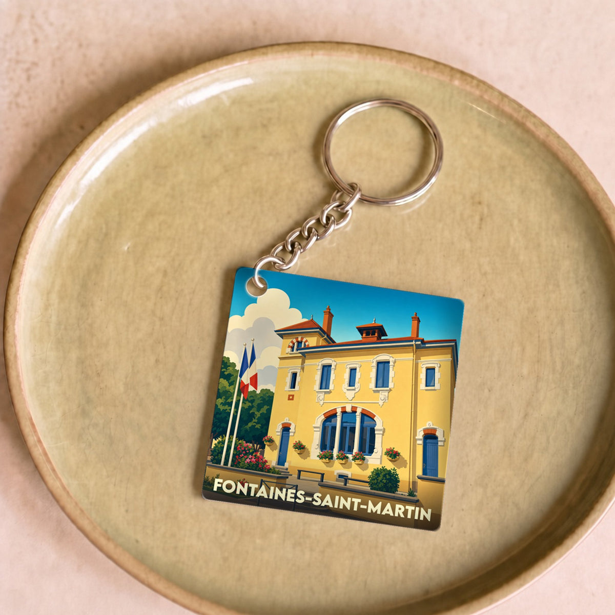 Porte-clés souvenir de la ville de Fontaines-Saint-Martin avec une illustration stylisée de sa mairie.