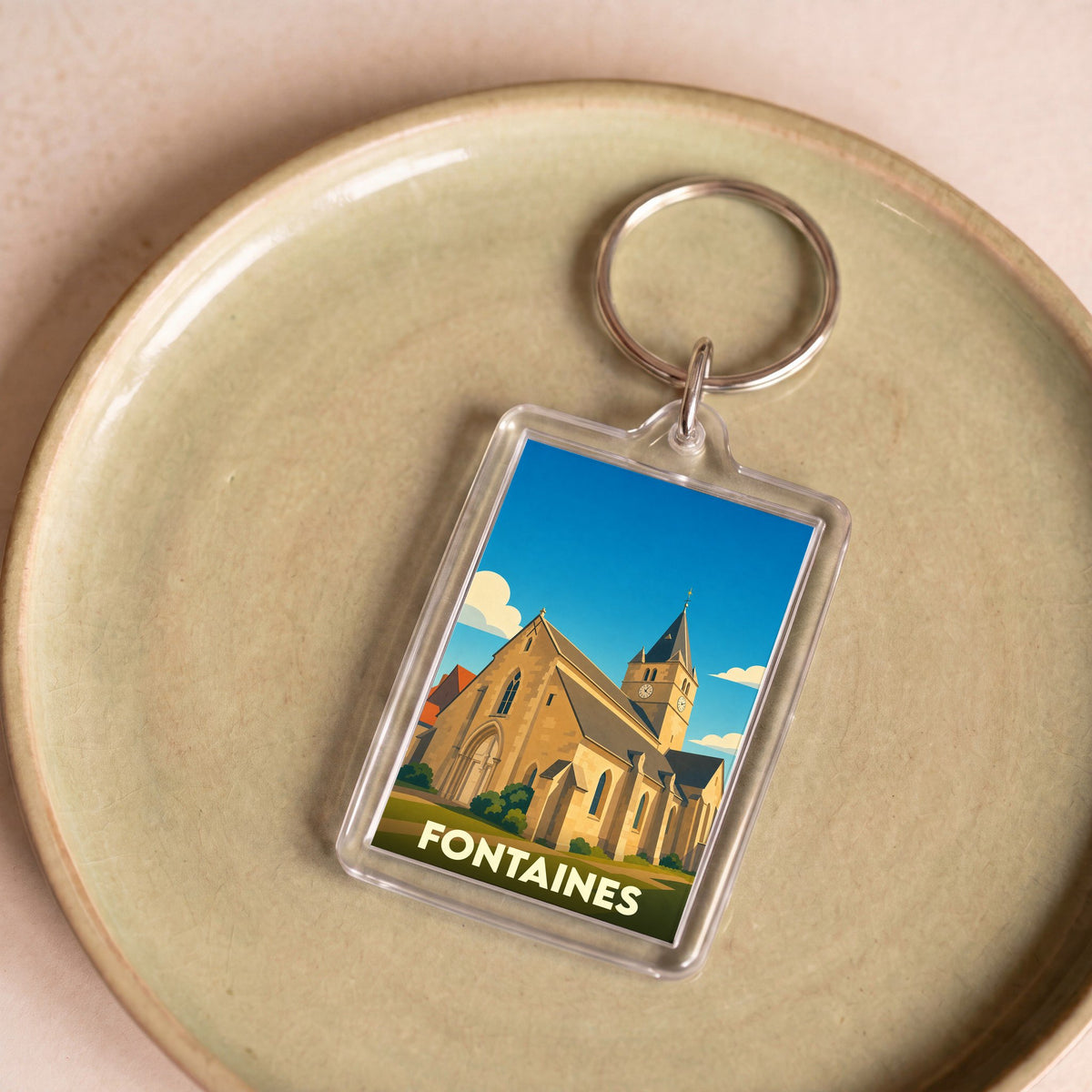 Porte-clés souvenir de la ville de Fontaines avec une illustration stylisée de son église.