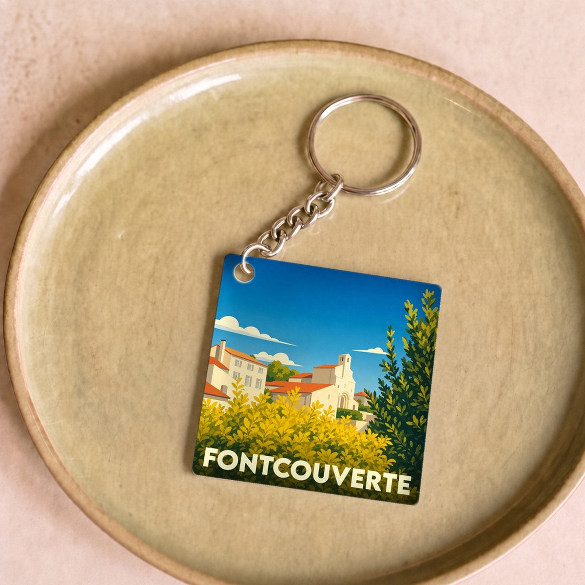 Porte-clés souvenir de la ville de Fontcouverte avec une illustration stylisée.