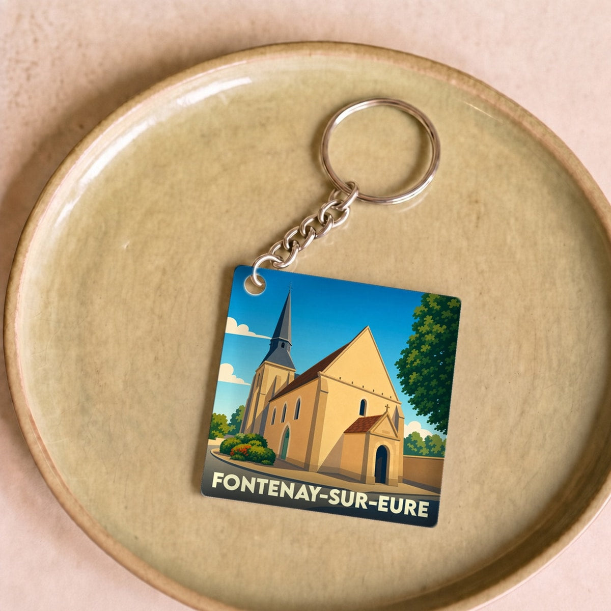 Porte-clés souvenir de la ville de Fontenay-sur-Eure avec une illustration stylisée de son église.