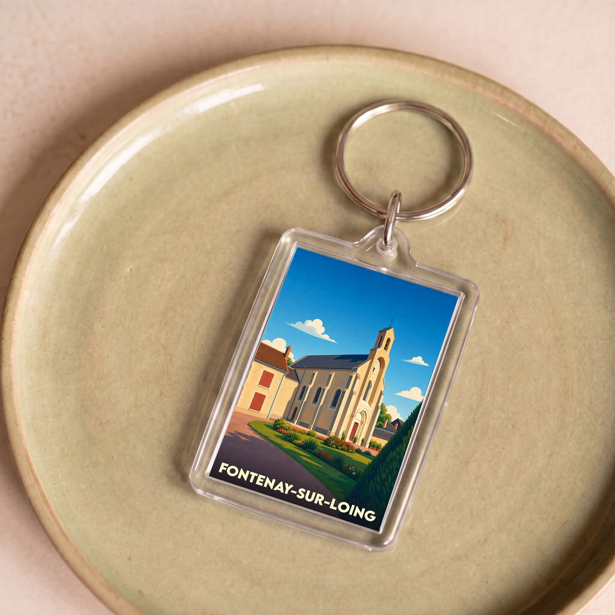 Porte-clés souvenir de la ville de Fontenay-sur-Loing avec une illustration stylisée de son église.